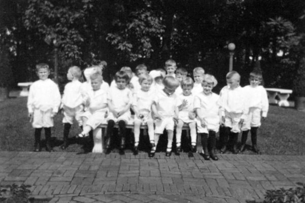 Boys standing near and sitting on a bench at High Point